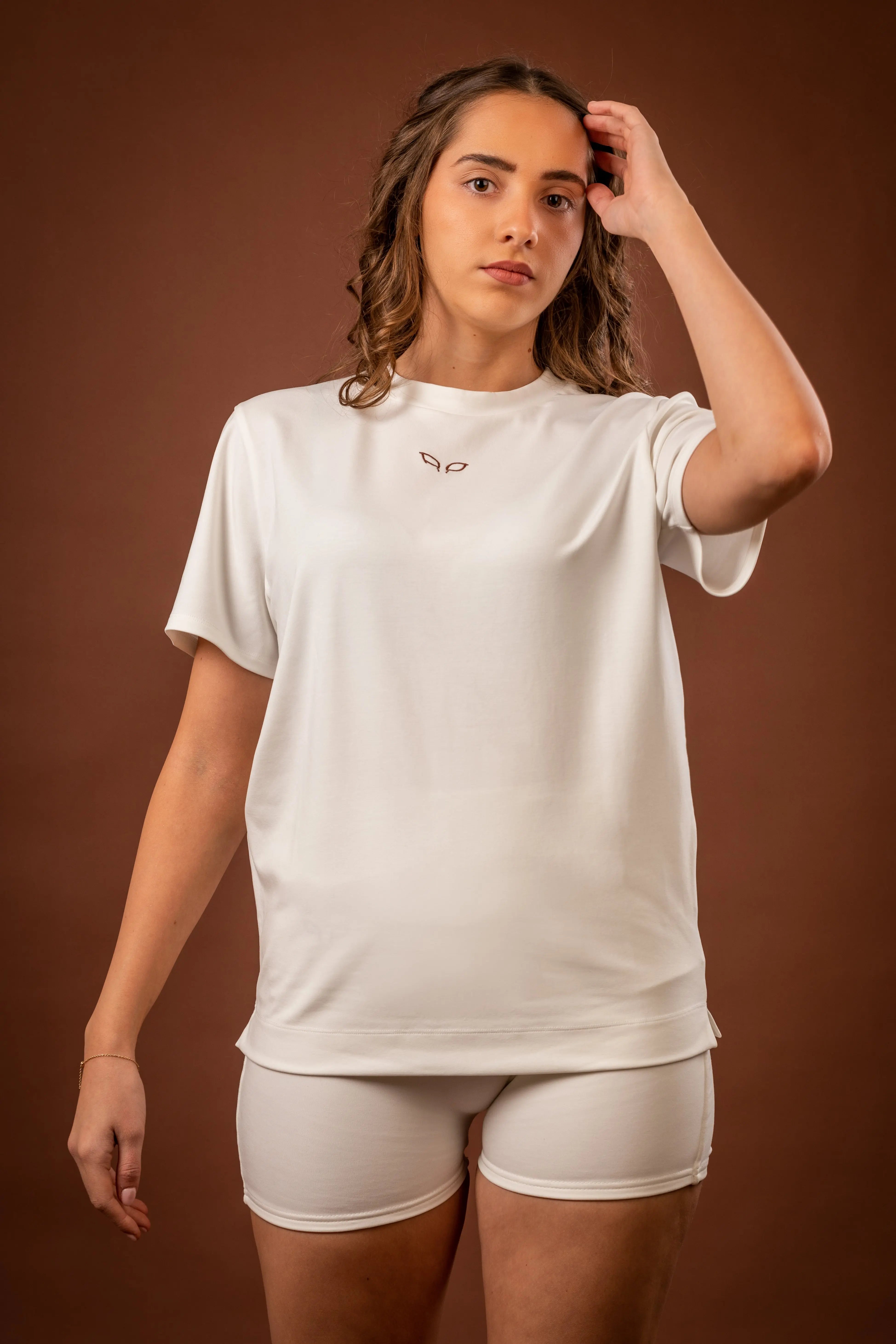 Amal t-shirt and Ergon shorts, a unisex sportswear and activewear symbiotic outfit made from sustainable and biosourced seaweed and wood fibers, with biodegradable elastane, free from toxic synthetics, eternal pollutants, and dyes, featuring the natural luminous color of the fibers in an off-white undyed shade.
