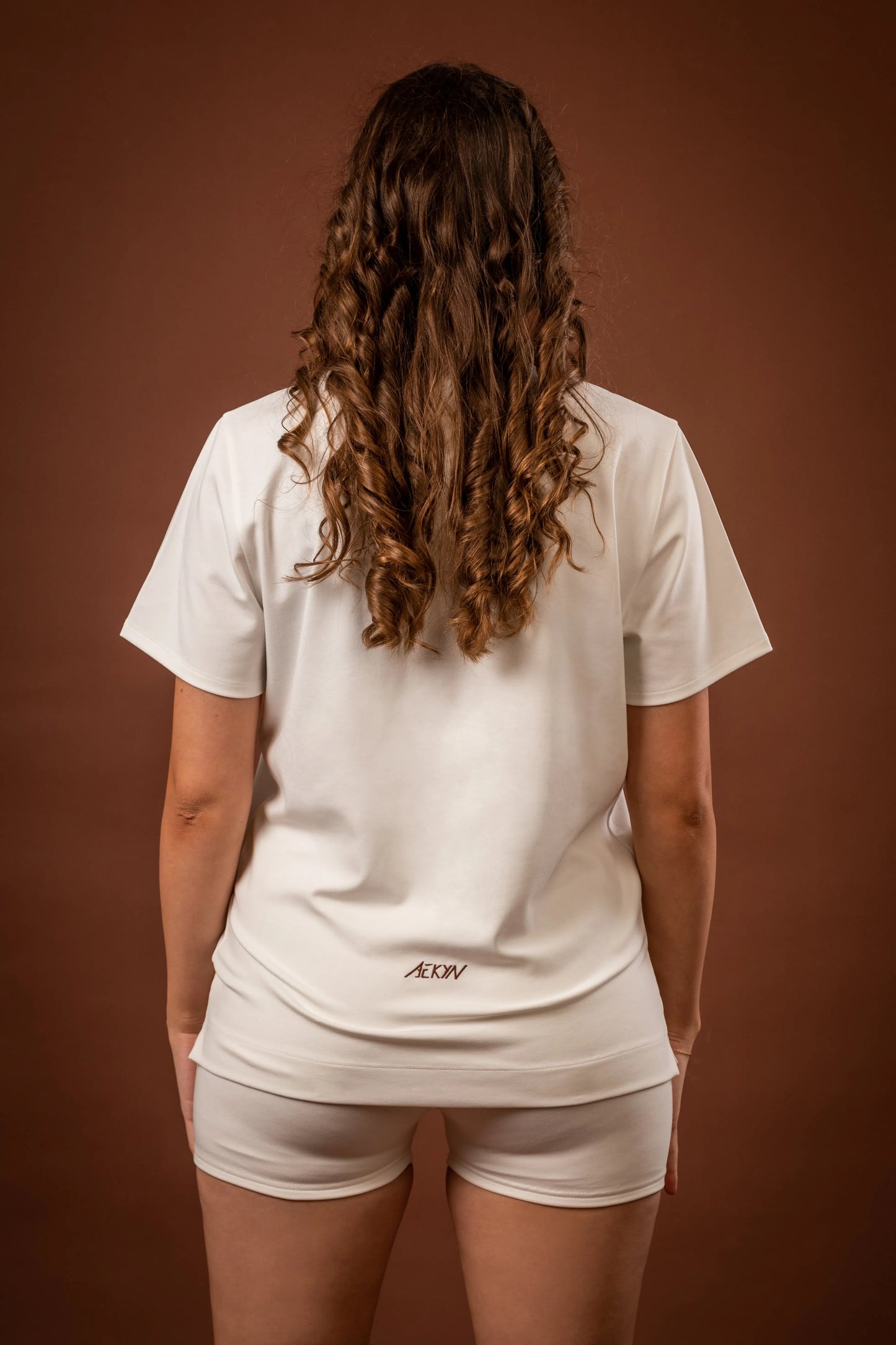 Amal t-shirt and Yuuki lined shorts, a versatile sportswear and activewear symbiotic outfit for women, made from sustainable and biosourced seaweed and wood fibers, with biodegradable elastane, free from toxic synthetics, eternal pollutants, and dyes, featuring the natural luminous color of the fibers in an off-white undyed shade