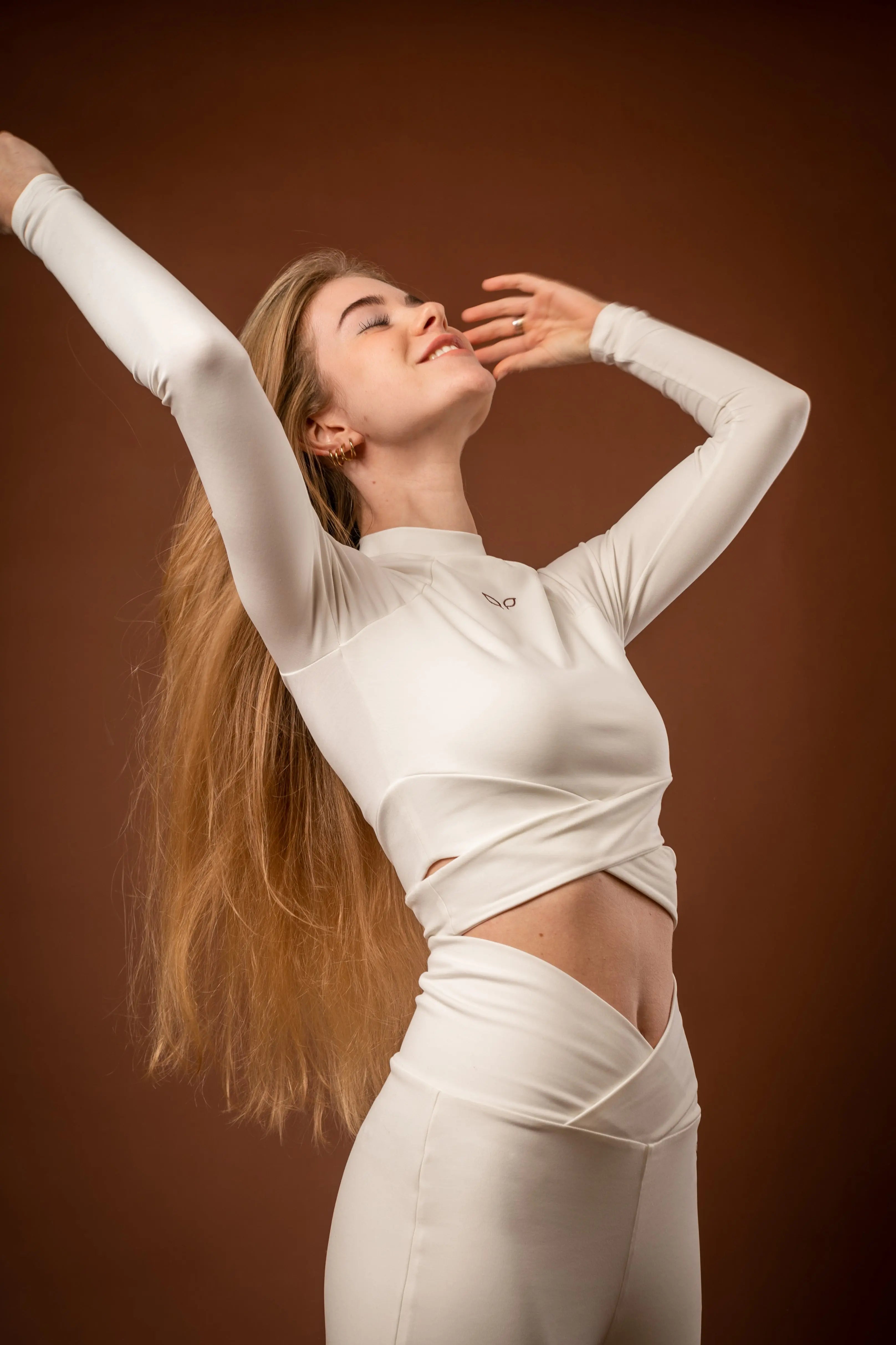 Kairos women's activewear long-sleeve top with crossed bands, made from sustainable and biosourced seaweed and wood fibers, with biodegradable elastane, free from toxic synthetics, eternal pollutants, and dyes, featuring the natural luminous color of the fibers in a white undyed off-white shade.
