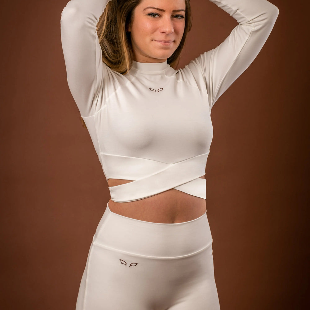 
                      
                        Kairos long-sleeve top and Yuuki lined shorts, a women's sportswear and activewear symbiotic outfit, crafted from sustainable and biosourced seaweed and wood fibers, with biodegradable elastane, free from toxic synthetics, eternal pollutants, and dyes, featuring the natural luminous color of the fibers in a white undyed off-white shade.
                      
                    
