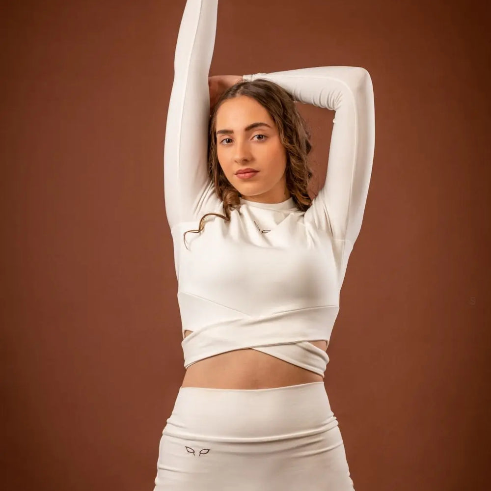 
                      
                        Kairos long-sleeve top and Yuuki lined shorts, a women's sportswear and activewear symbiotic outfit, crafted from sustainable and biosourced seaweed and wood fibers, with biodegradable elastane, free from toxic synthetics, eternal pollutants, and dyes, featuring the natural luminous color of the fibers in a white undyed off-white shade.
                      
                    